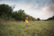 Girl in field by Texas best family photographer and videographer