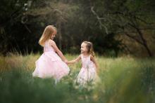 Two sisters playing in field near Southlake Colleyville Keller Texas during beautifully styled family photo shoot