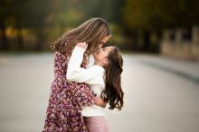 Two sisters hugging in beautiful street by Texas best fine art portrait photographer