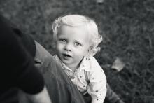 Black and white Little boy pulling on Dads pant let during outdoor family photo shoot near Trophy Club Southlake Roanoke Keller