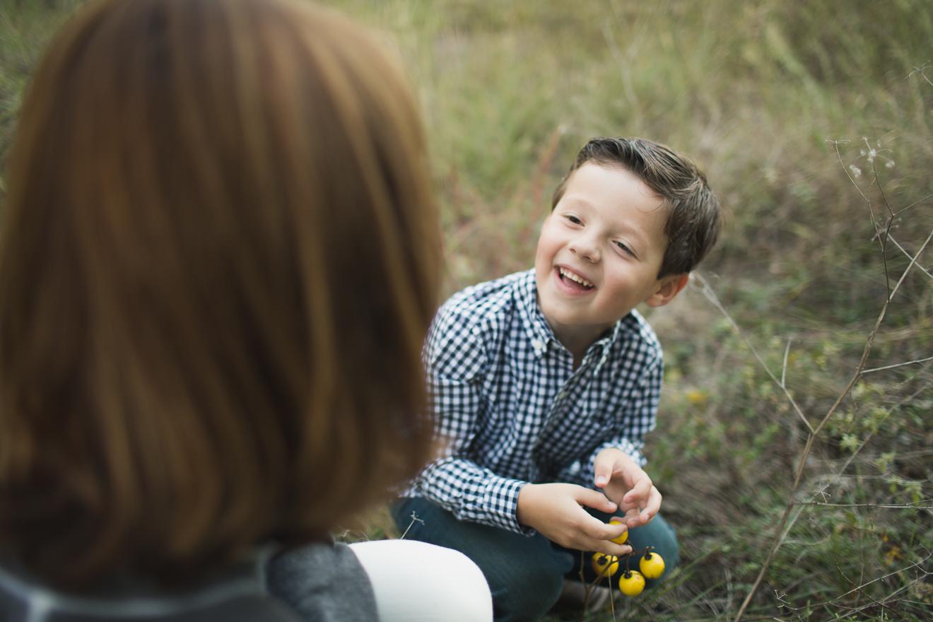 Boy laughing in field during family photo shoot near Colleyville Texas