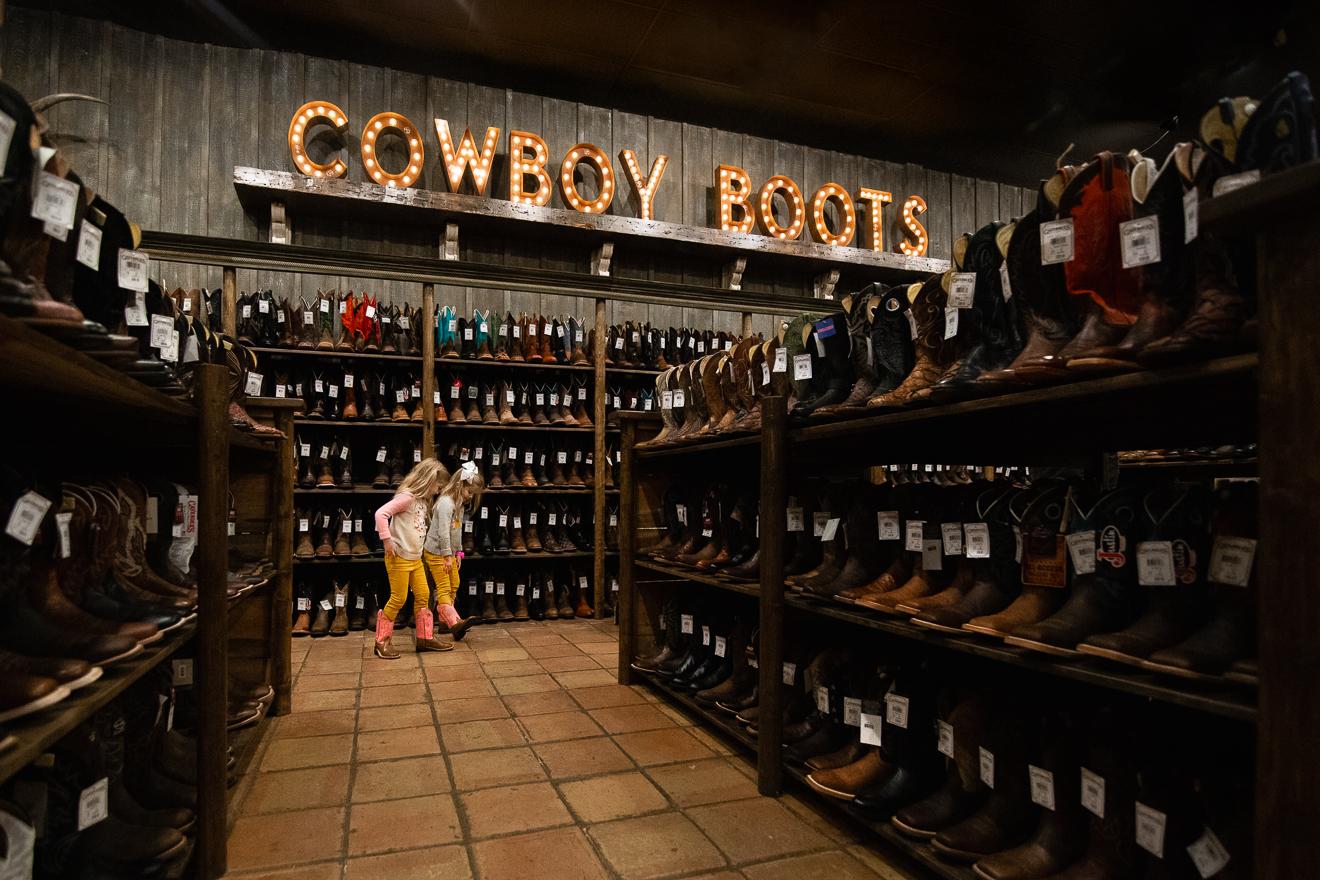 Colorful image of little girl twins shopping in a boot store in Ft Worth Texas Stockyards by award winning female photographer