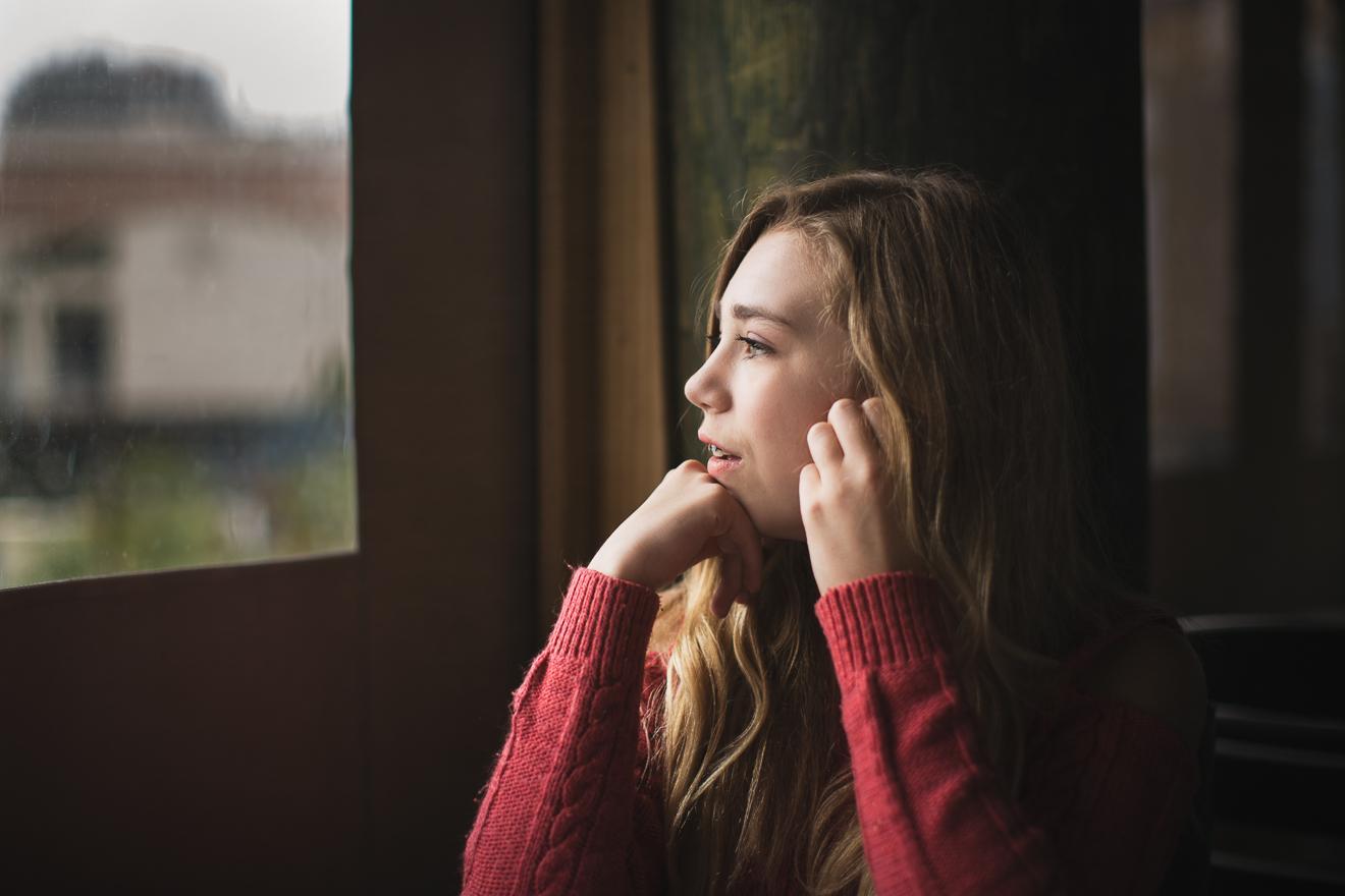 Lifestyle image of a girl gazing out a window by Sunny Mays Photography