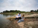 Toddler, Dad, and Mom sitting on Texas lakeshore By Sunny Mays