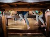 Colorful image of twin girls peaking under an old farmhouse kitchen table near Trophy Club Southlake Texas during a family documentary session