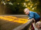 Colorful image of a little boy climbing a fence with beautiful light by award winning photographer in Trophy Club Southlake Roanoke Texas