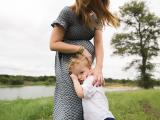 Professional family photography of a Boy snuggling pregnant mom in a field near Flower Mound Southlake Trophy Club Texas