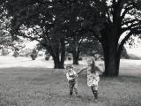 Brother and sister playing in field by fine art portrait photojournalistic photographer